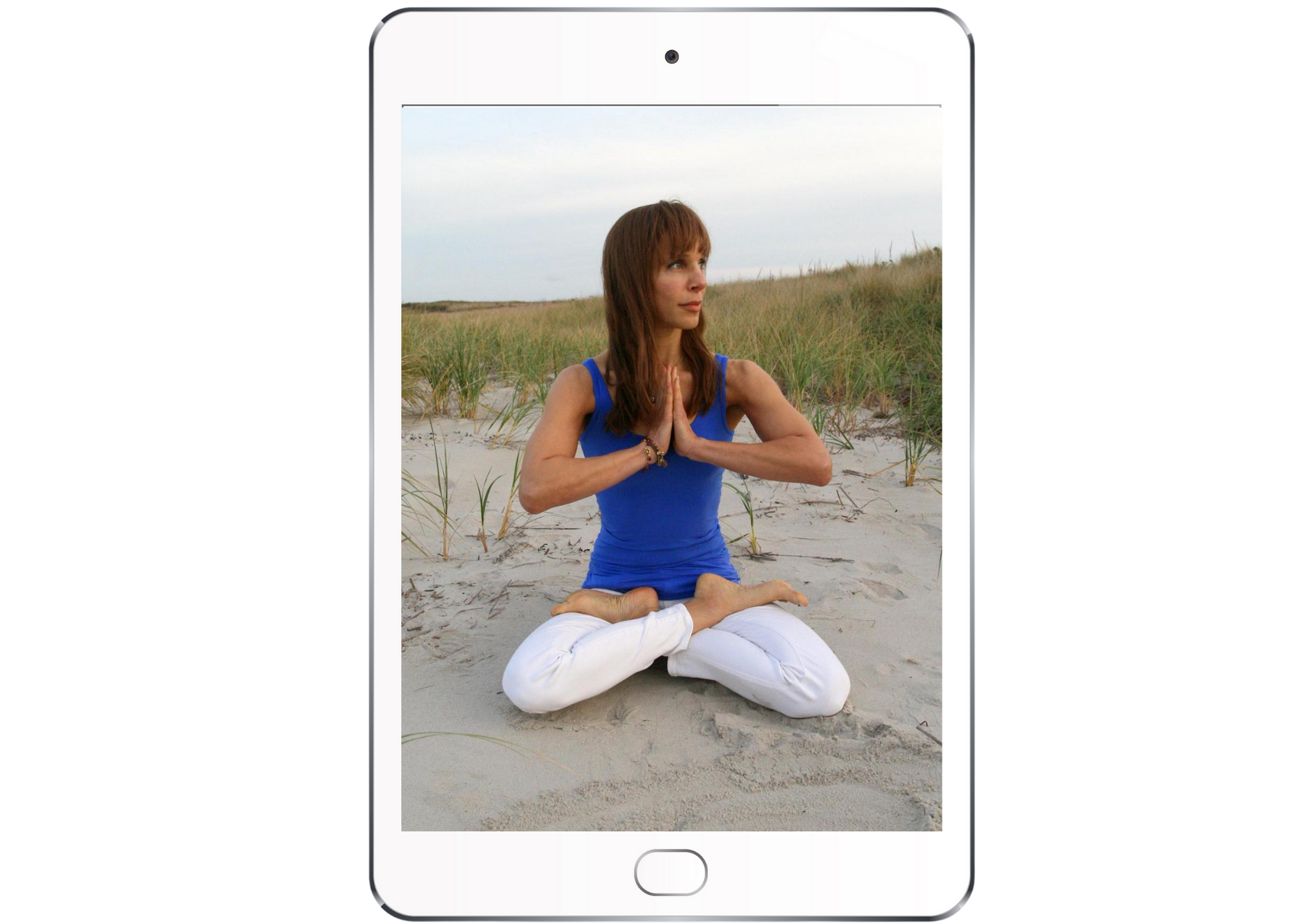 iPad with picture of Bo in lotus on the beach in white pants and a cobalt blue shirt, with dunes in the background