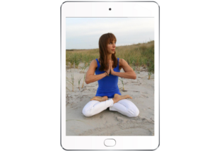 iPad with picture of Bo in lotus on the beach in white pants and a cobalt blue shirt, with dunes in the background